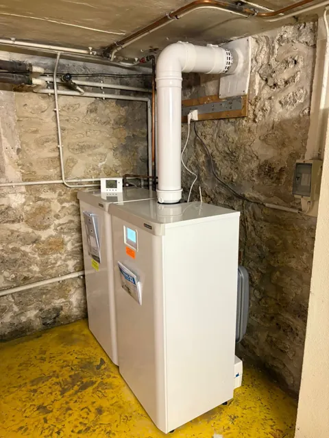 Installation de chauffage en sous-sol avec mur en pierre